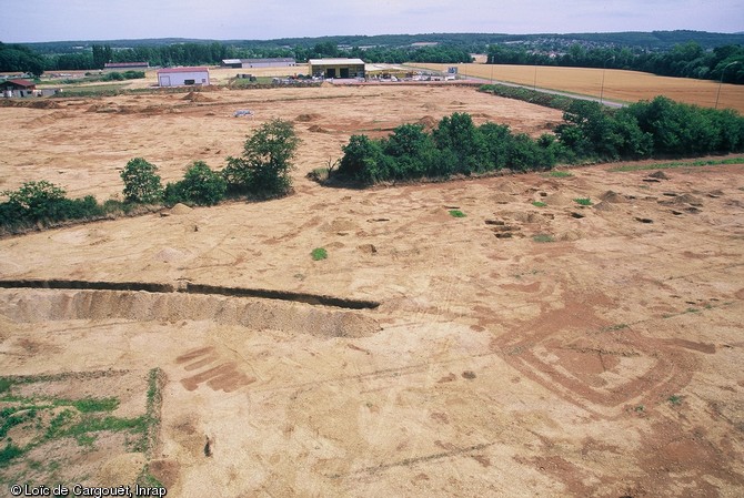 Vue de la tranchée de palissade néolithique recoupée par des enclos funéraires protohistoriques. Un groupe de sépultures protohistoriques sans enclos est visible devant la tranchée, commune de Monéteau (Yonne), 1999. 