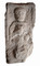 Stèle funéraire gallo-romain en arkose (hauteur 80 cm, largeur 41 cm), première moitié du IIe s. de notre ère, nécropole de Pont-l'Évêque, Autun (Saône-et-Loire), 2004.  La main droite du personnage présente un gobelet tandis que la gauche tient un objet mince et courbé, interprété comme une enclume mobile, attribut d’un artisan du métal.