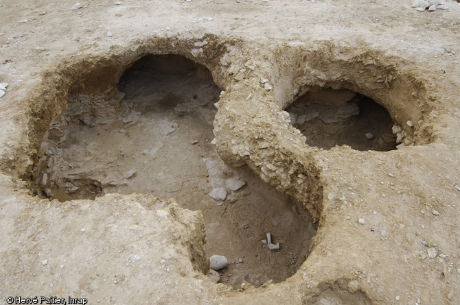 Vue d'un puits d'extraction du silex avec ses galeries. Fouille de la minière néolithique de Ri (Orne), 2007.  Environ 650 puits d'extractions du silex, destiné à la fabrication de lames de hache, ont été repérés sur les deux hectares du site. 