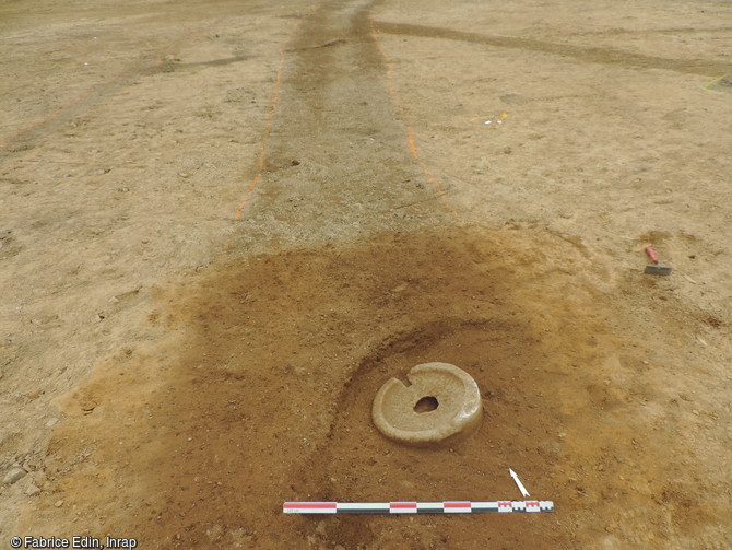 Meule rotative dans un fossé laténien en cours de fouille sur le site de Parc al Lann à Ergué-Gabéric (Finistère), 2016