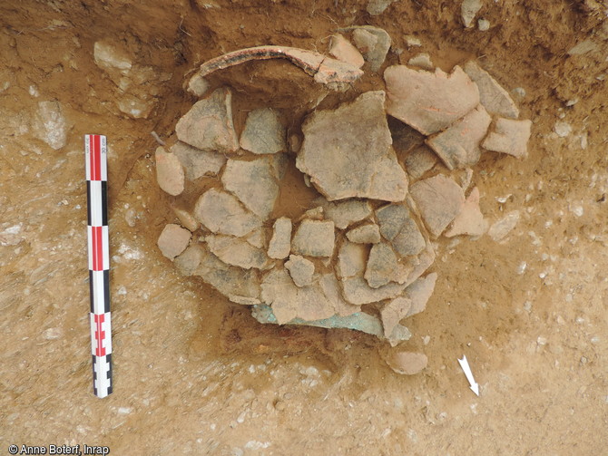 Vue du dépôt funéraire de l'âge du Bronze ancien : vase biconique à trois anses et poignard en bronze mis au jour dans une tombe sur le site de Parc al Lann à Ergué-Gabéric (Finistère), 2016