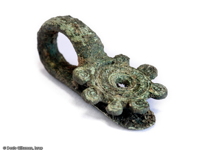 Fibule en bronze datée des années -40/-30 avant notre ère découverte sur le Mont Castel à Port-en-Bessin (Calvados).