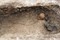 Vue d'ensemble du squelette d'un enfant âgé de 2 ans et demi d'après les mensurations des os, logé dans la paroi en sape, mis au jour dans le cimetière d'enfants de l'âge du Fer à Jort (Calvados).