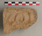 Fragment d'antéfixe (ornement de toiture) en terre cuite de fabrication massaliète (IVe siècle av. notre ère). Il porte un décor moulé non identifiable. Découvert dans une fosse mise au jour à Marseille (Bouches-du-Rhône) en 2021, qui était utilisée pour rejeter des résidus d'un atelier de potiers qui devait se situer à proximité. 