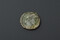 Face d'une monnaie en bronze, frappée en 335-336, représentant l'empereur Constantin 1er. Au revers, deux soldats armés et casqués tiennent des enseignes militaires. Découverte lors de la fouille de la Zac Pasteur à Besançon (Doubs) entre 2010 et 2011.