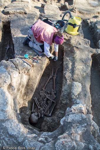 Vue d'une sépulture en cours de fouille dans le cimetière rupestre (VIIe-XIIe siècle) du quartier de Saint-Ferréol à Uzès (Gard). Le défunt repose dans un creusement de la forme du corps. 