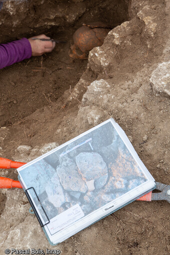 Sépulture en cours de fouille dans le cimetière rupestre (VIIe-XIIe siècle) du quartier de Saint-Ferréol à Uzès (Gard). Le défunt repose dans un creusement dans la roche à la forme de son corps.