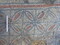 Détail des rosaces de la mosaïque mise au jour dans le centre historique de Nevers (Nièvre) en 2023. Les rares tessons de céramique et les charbons de bois découverts dans l'environnement stratigraphique de la mosaïque permettront peut-être de préciser sa date de construction et d'utilisation. Bien qu'une datation antique soit possible, sa contemporanéité avec la construction du baptistère (Ve-début VIe s.) est également envisageable tout comme une datation plus récente, jusque dans le Moyen-Âge central lors d'une réfection du baptistère. 