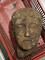 Tête de la statue en calcaire, sortie de terre datant de la 1ère moitié du 1er s. après notre ère, à Briord (Ain) en 2020. Les traits idéalisés sont celui d'un homme jeune et imberbe. 