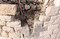 Détail de l'archère 76 de la tour sud du château Saint-Marcel à Marseille (Bouches-du-Rhône). Il s'agit d'une archère en capitale (c'est-à-dire bissectrice) à ébrasement simple équipée d'une plongée qui permet un tir plongeant. L'extrémité inférieure de la fente n'est pas évasée en étrier. Ce sont des marqueurs qui permettent d'attribuer la tour aux fortifications capétiennes précoces, en l'occurrence à Charles 1er d'Anjou, frère de Louis IX, qui occupe le château entre 1264 et 1276. 