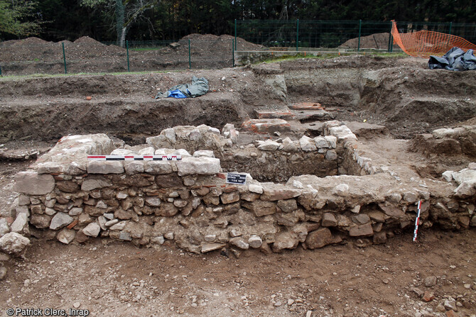 Vue du mur formant le pignon nord du moulin sans sa seconde phase d'occupation (fin XVIIe - début XVIIIe siècle).Il est constitué de moellons en grès et granite, de briques, de tuiles digitées et est conservé sur 70 à 130 cm de hauteur.