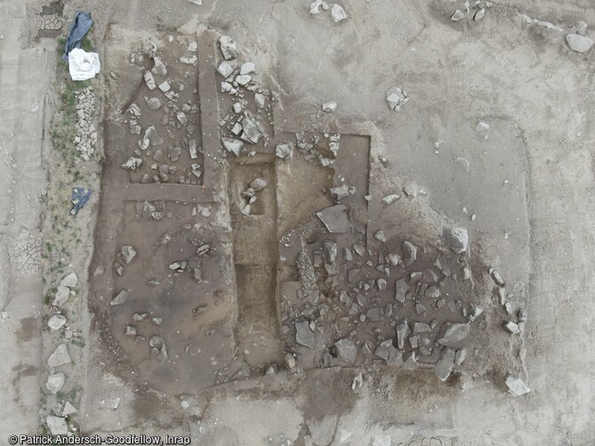 Vue aérienne autour des fosses néolithiques et du bâtiment sur le site de la Carella à Font-Romeu-Odeillo-Via (Pyrénées Orientales). Au centre, à droite de la tranchée, les murs en pierre et terre et la fosse 7037 en cours de fouille. A gauche de la tranchée, marquée par un sédiment sombre la fosse 7052 non encore fouillée. Un autre aménagement en terre crue est visible par un tracé jaunâtre au bord de la fosse 7052. 