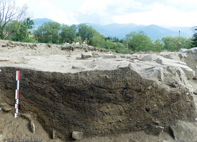 Coupe de la fosse 7052 du Néolithique, avec les niveaux rubéfiés et charbonneux ainsi que le dôme en terre crue, sur le site de la Carella à Font-Romeu-Odeillo-Via (Pyrénées Orientales).