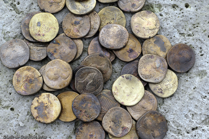 Sesterces de bronze du dépôt monétaire des Mesneux (Marne), 2010.  Environ 340 monnaies de bronze (représentant près de 8 kg de métal), toutes frappées au IIe s. de notre ère entre les règnes d'Hadrien et de Septime Sévère, ont été mises au jour dans ce dépôt cultuel constitué en une fois au IIIe s. 