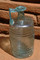 Petite bouteille en verre, intacte et de type  barillet frontinien , mise au jour dans la sépulture à inhumation avec caveau en briques, IIe-IIIe s. de notre ère, Neuville-sur-Sarthe (Sarthe), 2010. 