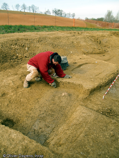 Nettoyage manuelle d'une sépulture, cimetière médiéval de Marsan (Gers), 2008.  La différence de couleur et de texture entre le comblement et le sédiment encaissant permet de délimiter le creusement de la sépulture. 