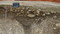 Coupe du fossé d'enclos avec scellement de pierres calcaires, Ier s. de notre ère, Épieds-en-Beauce (Loiret), 2011.  Le site, fossés compris, était scellé uniformément par des pierres calcaires locales qui ont permis une conservation exceptionnelle de la stratigraphie sur 70 cm d'épaisseur. 