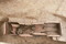 Vue de l'intérieur du coffrage en tuiles de la tombe à libations, Ier-IIIe s. de notre ère, Portbail (Manche), 2012.Une jeune femme y est inhumée avec deux pièces de monnaie en bronze, expression du rite de  l'obole à Charron . Sur la gauche, le coussin céphalique est réalisé au moyen d'une imbrex (tuile arrondie). Le basculement est du à la décomposition du corps.