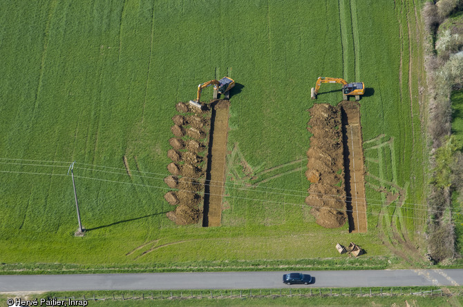 Vue aérienne de sondages archéologiques en Mayenne, 2010.Le diagnostic archéologique est réalisé le plus souvent à la pelle mécanique. Les archéologues suivent la pelle et s’assurent de la présence ou non de vestiges. Le diagnostic permet de caractériser le site et de le dater. En fonction des résultats, une fouille est prescrite par le Préfet de région après instruction du dossier par le service régional de l’Archéologie.