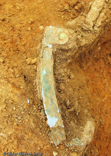 Bouterolle du fourreau, alliage à base de cuivre, dépôt d'armes de la fin du IVe - début du Ve s. de notre ère, Fontenay-sur-Vègre (Sarthe), 2012.