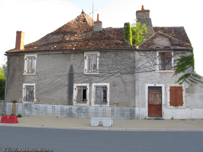 Façade sur rue, des constructions du XIXe siècle incorporant les vestiges de l'enceinte de la basse-cour du début du XVe siècle de l'abbaye Saint-Pierre à Méobecq (Indre), 2011.