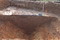 Détail en coupe de la morphologie et du remplissage du fossé d'enclos de la ferme de la fin de la période gauloise (IIe et 1er siècle avant notre ère) à Valognes (Manche), 2015.